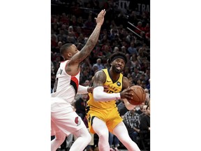 Indiana Pacers guard Wesley Matthews, right, drives to the basket against Portland Trail Blazers guard Damian Lillard, left, during the first half of an NBA basketball game in Portland, Ore., Monday March 18, 2019.