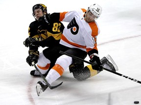 Philadelphia Flyers' Michael Raffl (12) collides with Pittsburgh Penguins' Sidney Crosby (87) during the first period of an NHL hockey game in Pittsburgh, Sunday, March 17, 2019.