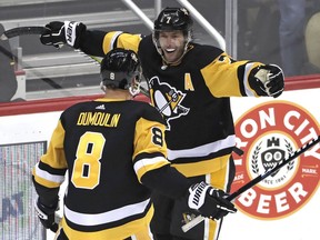 Pittsburgh Penguins' Matt Cullen (7) celebrates his goal with Brian Dumoulin during the first period an NHL hockey game against the Carolina Hurricanes in Pittsburgh, Sunday, March 31, 2019.