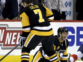 Pittsburgh Penguins' Matt Cullen, lower right, stretches during warmups for his 1,500th career NHL hockey game before facing the Florida Panthers in Pittsburgh, Tuesday, March 5, 2019. The entire Penguins team wore Cullen's No. 7 jerseys during warmups. Cullen is the second American-born player to reach the 1,500 game plateau. Chris Chelios is first with 1,651 NHL games played.