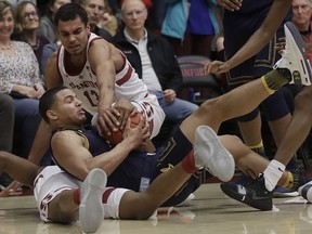 California guard Matt Bradley, center, tries to control the ball between Stanford forward Oscar Da Silva, top, and KZ Okpala during the first half of an NCAA college basketball game in Stanford, Calif., Thursday, March 7, 2019.