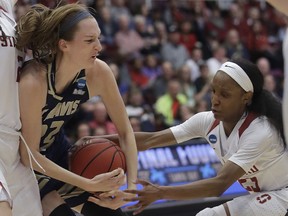 Stanford guard Kiana Williams, right, reaches for the ball as UC Davis forward Morgan Bertsch tries to hold onto it during the first half of a first-round game in the NCAA women's college basketball tournament in Stanford, Calif., Saturday, March 23, 2019.