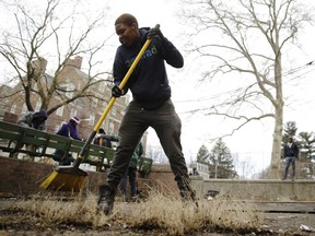 In this Feb. 15, 2019, photo, Najae Hill takes part in the Fresh Start initiative to clean up trash in the Germantown neighborhood of Philadelphia. Philadelphia has been trying for years to shed itself of the nickname "Filthadelphia." Now some neighborhoods struggling with litter have decided to take collection into their own hands.