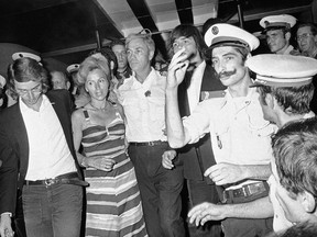 FILE - In this July 5, 1976 file photo, head pilot Michel Bacos, center left, is reunited with his wife, 2nd left, and son at Orly Airport near Paris, France, as the 12-member crew of the hijacked Air France Airbus jetliner and 14 passengers return home from Tel Aviv after a week-long stay at Entebbe Airport in Uganda. The French pilot of the Air France plane hijacked to Uganda's Entebbe airport in 1976, in which 110 hostages were freed by Israeli commandos, has died at the age of 95. (AP Photo, File)