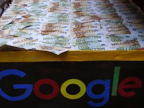 FILE - In this Jan.31, 2019 file photo, a trunk full of fake bank notes is displayed as activists from anti-globalization organisation Attac stage a protest at Google's Paris headquarters to criticize the company's tax evasion policies, in Paris. The French government is unveiling plans to slap a 3 percent tax on the French revenues of internet giants like Google, Amazon and Facebook.