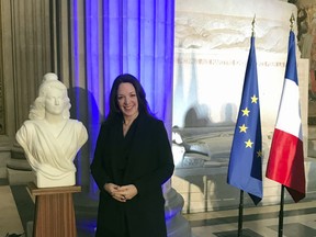 Britain's Catherine Norris Trent poses next to a bust of Marianne, left, symbol of the French Republic, and the French, right, and European flags after a naturalization ceremony in Paris' Pantheon monument, Thursday, March 21, 2019. With the looming Brexit deadline, the 38-year-old mother of two who's lived in the French capital for over a decade was one of dozens of newly-minted French nationals attending the cermony.