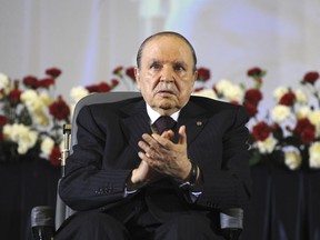 FILE - In this April 28, 2014 file photo, Algerian President Abdelaziz Bouteflika, sitting in a wheelchair, applauds after taking the oath as President in Algiers. Algeria's powerful army chief wants to trigger the constitutional process that would declare ailing President Abdelaziz Bouteflika unfit for office.