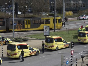 Ambulances are parked next to a tram after a shooting incident in Utrecht, Netherlands, Monday, March 18, 2019. A gunman killed three people and wounded nine others on a tram in the central Dutch city of Utrecht, sparking a manhunt that saw heavily armed officers with sniffer dogs zero in on an apartment building close to the shooting.