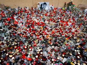 FILE- In this Friday, March 16, 2018 file photo candles are placed in memory of slain journalist Jan Kuciak and his fiancee Martina Kusnirova during a rally in Bratislava, Slovakia. On Thursday, March 14, 2019, Slovakia's police said they have charged a suspect with ordering the slaying of an investigative reporter and his fiancee, a case that brought down the Slovak government. Police didn't immediately name the suspect. Jan Kuciak and Martina Kusnirova were shot dead in their home on Feb. 21 2018.