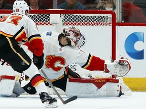 Calgary Flames goaltender Mike Smith, right, gives up a goal to Arizona Coyotes' Clayton Keller as Flames center Sam Bennett (93) looks on during the first period of an NHL hockey game Thursday, March 7, 2019, in Glendale, Ariz.