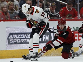 Arizona Coyotes center Clayton Keller (9) pokes the puck away from Chicago Blackhawks center Dylan Strome (17) during the first period of an NHL hockey game Tuesday, March 26, 2019, in Glendale, Ariz.