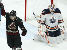 Arizona Coyotes right wing Conor Garland (83) celebrates a goal by teammate Alex Galchenyuk against Edmonton Oilers goaltender Mikko Koskinen (19) during the first period of an NHL hockey game Saturday, March 16, 2019, in Glendale, Ariz.