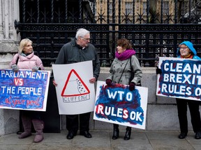 Pro-Brexit activists hold banners as they demonstrate outside the Houses of Parliamnet in London on March 12, 2019, ahead of the debate leading to the second meaningful vote on the government's Brexit deal.