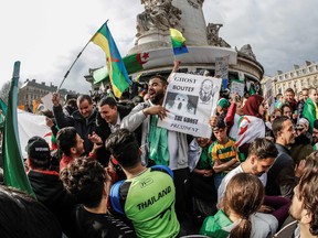 Demonstrators wave Algerian flags during a protest over fears of plot to prolong the Algerian president's rule, on Place de la Republique (Republic's Square) in Paris, on March 24, 2019.