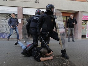 Police officers pin a demonstrator to the ground during a protest against a rally by the Spanish far-right Vox party in Barcelona, Spain, Saturday March 30, 2019. Spain hadn't had a far-right party for years until Vox erupted onto the political scene by winning representation in regional elections in the country's south in December.