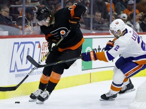 Philadelphia Flyers' Nolan Patrick, left, tries to keep the puck away from New York Islanders' Nick Leddy during the second period of an NHL hockey game, Saturday, March 23, 2019, in Philadelphia.