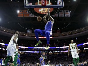 Philadelphia 76ers' Joel Embiid (21) dunks as Boston Celtics' Kyrie Irving, Marcus Morris and Al Horford, from left, watch during the second half of an NBA basketball game Wednesday, March 20, 2019, in Philadelphia. Philadelphia won 118-115.