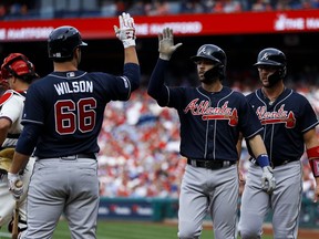 From right to left, Atlanta Braves' Tyler Flowers, Dansby Swanson, Tyler Flowers and Bryse Wilson celebrate past Philadelphia Phillies catcher J.T. Realmuto after Swanson's two-run home off starting pitcher Nick Pivetta during the second inning of a baseball game, Saturday, March 30, 2019, in Philadelphia.