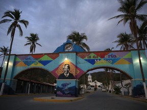 A mural of Nelson Mandela, who spent 18 of his 27 imprisoned years in an island prison in South Africa, adorns a gate in front of the dock where prison staff and inmates arrive in Navy boats to the now closed Islas Maria penal colony located off Mexico's Pacific coast, at dawn Sunday, March 17, 2019. Islas Marias was the last of its kind, the final of a half dozen island penal colonies that were scattered around Latin America.