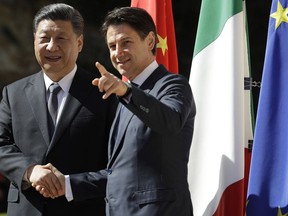 Chinese President Xi Jinping, left, and Italian Premier Giuseppe Conte shake their hands as they meet at Rome's Villa Madama, Saturday, March 23, 2019.