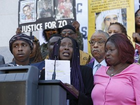 Sequitta Thompson, second from left, the grandmother of police shooting victim Stephon Clark, calls for justice for her grandson during a news conference at the Capitol on Monday, March 18, 2019, in Sacramento, Calif. Monday marks a year since two Sacramento police officers killed Clark, 22, in Thompson's backyard as they responded to vandalism reports. Thompson was joined by Clark's brother, Stevante, left, The Rev. Al Sharpton, third from left, and Clark's mother, SeQuette Clark, right,