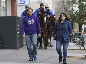 Sacramento Kings fans Nick and Emily Brown walked to the Golden 1 Center Arena, as horse mounted Sacramento Police Officers patrol the area around the arena before the Kings play the New York Knicks in an NBA basketball game in Sacramento, Calif., Monday, March 4, 2019. Extra security has been added around the home of the Kings in the wake of Saturday's announcement by Sacramento County District Attorney Anne Marie Schubert Sacramento Police Officers Terrance Mercadal and Jared Robinet did not break any laws when they shot and killed Stephon Clark after the 22-year-old vandalism suspect ran from them into his grandparents backyard last year.