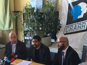 Juliano Gray, centre, speaks to reporters alongside Centre for Research-Action on Race Relations executive director Fo Niemi, left, and Alain Babineau, in Montreal on Tuesday, March 26, 2019. Gray was beaten with batons by transit inspectors on March 7 after being caught without a valid fare in an incident captured by a bystander.