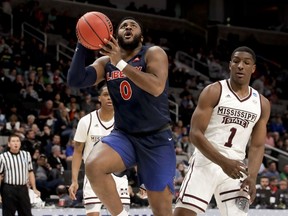 Liberty forward Myo Baxter-Bell, left, drives to the basket past Mississippi State forward Reggie Perry during the first half of a first-round men's college basketball game in the NCAA Tournament on Friday, March 22, 2019, in San Jose, Calif.