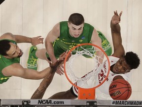 Wisconsin guard Khalil Iverson, right, shoots against Oregon forward Paul White, left, and guard Payton Pritchard during the first half of a first round men's college basketball game in the NCAA Tournament, Friday, March 22, 2019, in San Jose, Calif.