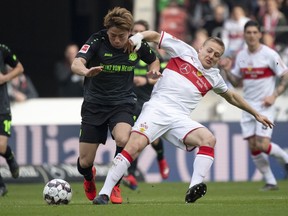 Stuttgart's Santiago Ascacibar, right, and Hannovers Takuma Asano, left, challenge for the ball during the German Bundesliga soccer match between VfB Stuttgart and Hannover 96 in Stuttgart, Germany, Sunday, March 3, 2019.