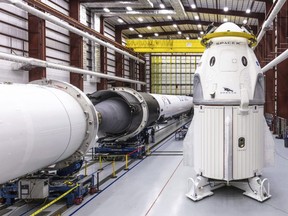 In this Dec. 18, 2018 photo provided by SpaceX, SpaceX's Crew Dragon spacecraft and Falcon 9 rocket are positioned inside the company's hangar at Launch Complex 39A at NASA's Kennedy Space Center in Florida, ahead of the Demo-1 unmanned flight test.