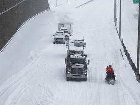 Police and safety crews on snowmobiles try to clear up Highway 13 in Montreal on March 15, 2017 following a massive snowstorm that left many motorists stranded overnight.