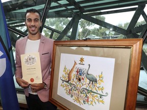 Hakeem al-Araiby, a former Bahraini international soccer player and refugee displays his certificate after becoming an Australian citizen, four weeks after escaping extradition to his homeland during a much-publicized detention in a Thai prison, in Melbourne, Tuesday, March 12, 2019. Al-Araiby, who fled Bahrain citing political repression, had lived under refugee status in Australia for more than a year until detained in Bangkok in November while on holiday.