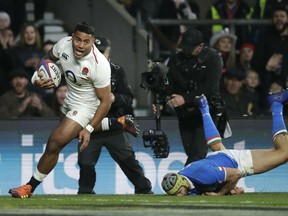England's Manu Tuilagi, left, gets away from Italy's Angelo Esposito to score a try during the Six Nations rugby union international match between England and Italy at Twickenham stadium in London, Saturday, March 9, 2019.