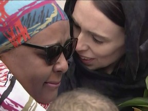 In this image made from video, New Zealand's Prime Minister Jacinda Ardern, right, hugs and consoles a woman as she visited Kilbirnie Mosque to lay flowers among tributes to Christchurch attack victims, in Wellington, Sunday, March 17, 2019. (TVNZ via AP)