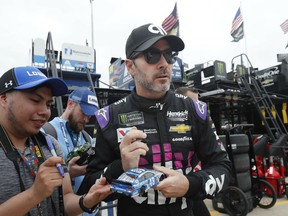 Jimmie Johnson looks up while signing autographs before practice for the NASCAR Cup Series auto race at Texas Motor Speedway in Fort Worth, Texas, Friday, March 29, 2019.