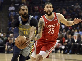 Memphis Grizzlies guard Mike Conley (11) handles the ball next to Houston Rockets guard Austin Rivers (25) during the first half of an NBA basketball game Wednesday, March 20, 2019, in Memphis, Tenn.