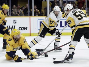 Nashville Predators defenseman Mattias Ekholm (14), of Sweden, goes down on the ice to block a shot by Pittsburgh Penguins left wing Jake Guentzel (59) during the first period of an NHL hockey game Thursday, March 21, 2019, in Nashville, Tenn.