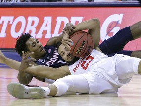 Connecticut guard Christian Vital and Houston's Galen Robinson Jr. scramble for a loose ball during the first half of an NCAA college basketball game at the American Athletic Conference tournament Friday, March 15, 2019, in Memphis, Tenn.