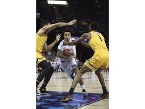 Wichita State player Markis McDuffie and Jaime Echenique try to defend as Cincinnati's Cane Broome drives to the basket in the first half of an NCAA college basketball game at the American Athletic Conference tournament Saturday, March 16, 2019, in Memphis, Tenn.