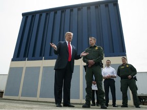 In this March 13, 2018, file photo, President Donald Trump talks with reporters as he reviews border wall prototypes in San Diego.