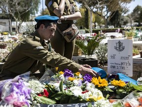 Israeli soldiers and friends of Staff Sgt. Gal Keidan mourn at his grave after the funeral in the city of Beersheba, Monday, March 18, 2019. Keidan was killed by Palestinian assailant in the West Bank Sunday.