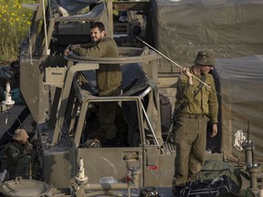 Israeli soldiers sit on top of mobile artillery near the border with Gaza, in southern Israel, Wednesday, March 27, 2019.