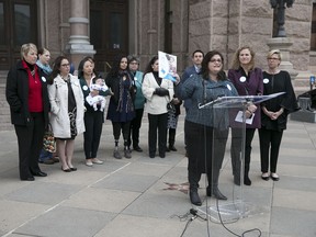 FILE - In this Dec. 7, 2016, file photo, Anna Dragsbaek, president and CEO of The Immunization Partnership, holds up a copy of the nonprofit's report on the status of vaccinations in Texas during a news conference at the Capitol in Austin, Texas. Nearly 50 people in the Texas Capitol received booster shots after a whooping cough scare on the House floor, bringing immunization battles close to home in a chamber where politically active anti-vaccination groups have moved to claim territory.