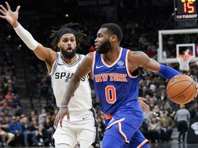 New York Knicks' Kadeem Allen (0) drives against San Antonio Spurs' Patty Mills during the first half of an NBA basketball game Friday, March 15, 2019, in San Antonio.