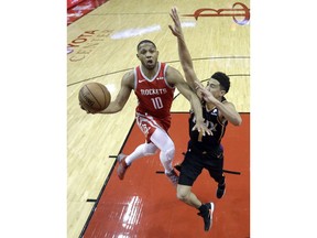 Houston Rockets' Eric Gordon (10) goes up for a shot as Phoenix Suns' Devin Booker (1) defends during the first half of an NBA basketball game Friday, March 15, 2019, in Houston.