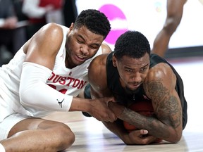 Houston's Breaon Brady, left, and Southern Methodist's Isiaha Mike reach for a loose ball during the first half of an NCAA college basketball game Thursday, March 7, 2019, in Houston.