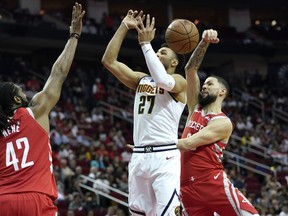 Denver Nuggets' Jamal Murray (27) has his shot blocked by Houston Rockets' Austin Rivers, right, as Nene Hilario (42) defends during the first half of an NBA basketball game Thursday, March 28, 2019, in Houston.