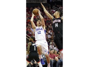 Philadelphia 76ers' T.J. McConnell (12) shoots as Houston Rockets' Gerald Green (14) defends during the first half of an NBA basketball game Friday, March 8, 2019, in Houston.