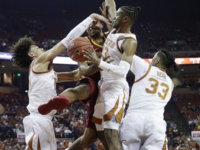 Iowa State guard Talen Horton-Tucker, second from left, is fouled as he drives to the basket against Texas defenders Jaxson Hayes, left, Jase Febres (13) and Kamaka Hepa (33) during the first half of an NCAA college basketball game, Saturday, March 2, 2019, in Austin, Texas.